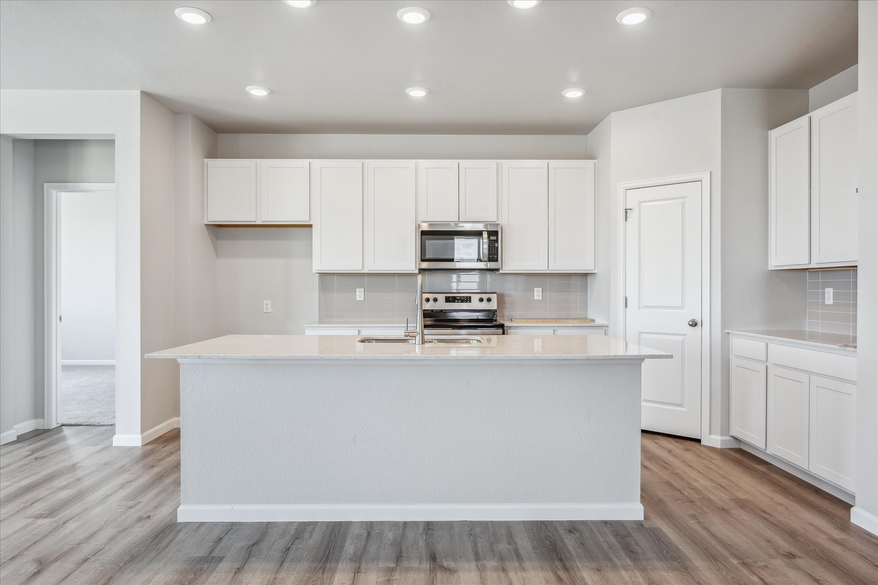 A kitchen with white cabinets.