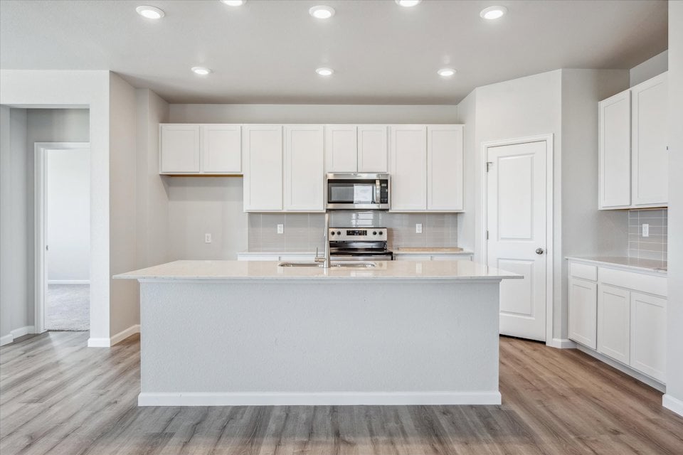 A kitchen with white cabinets.