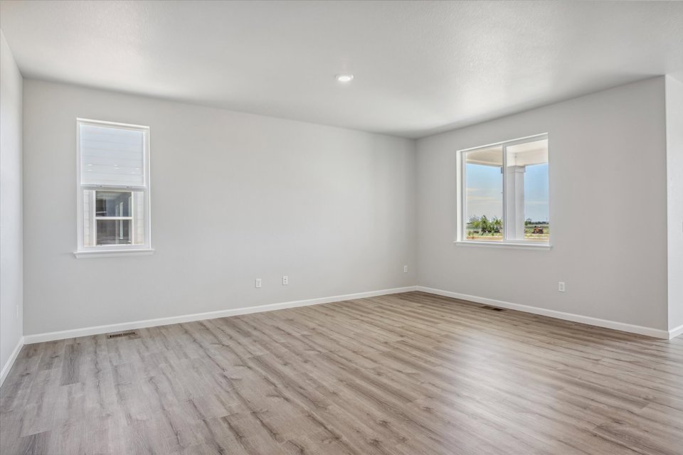 A room with a wood floor and windows.