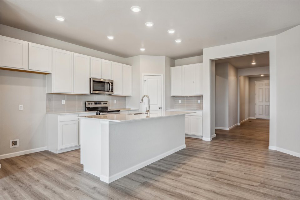 A kitchen with white cabinets.