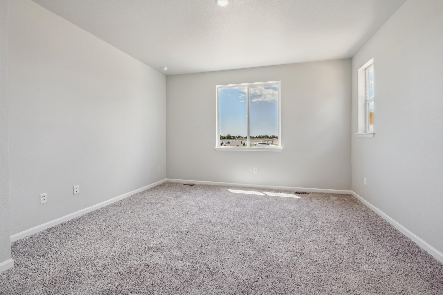 A room with a window and a carpet.