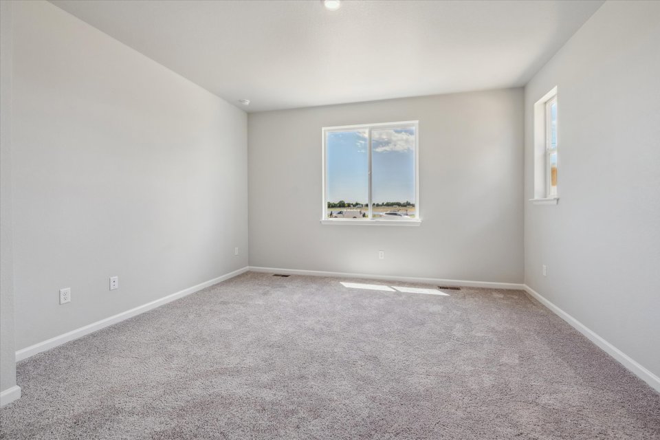 A room with a window and a carpet.