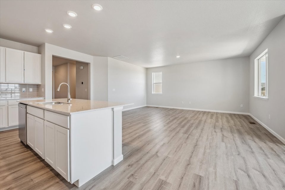 A kitchen with white cabinets.