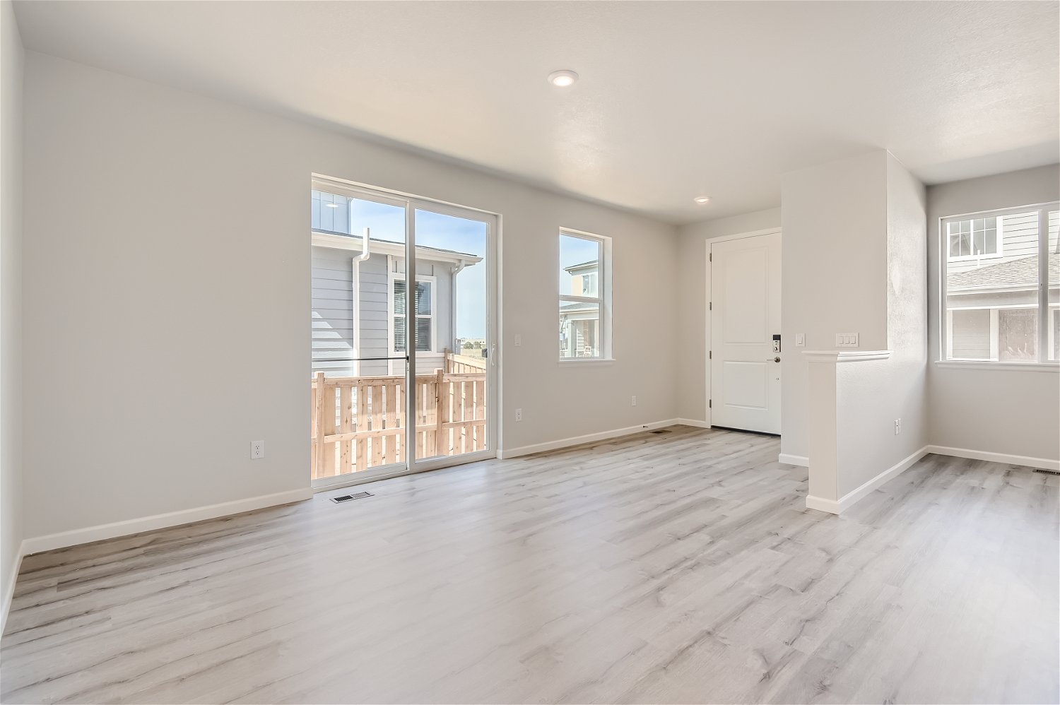A large empty room with a wood floor and a large window.