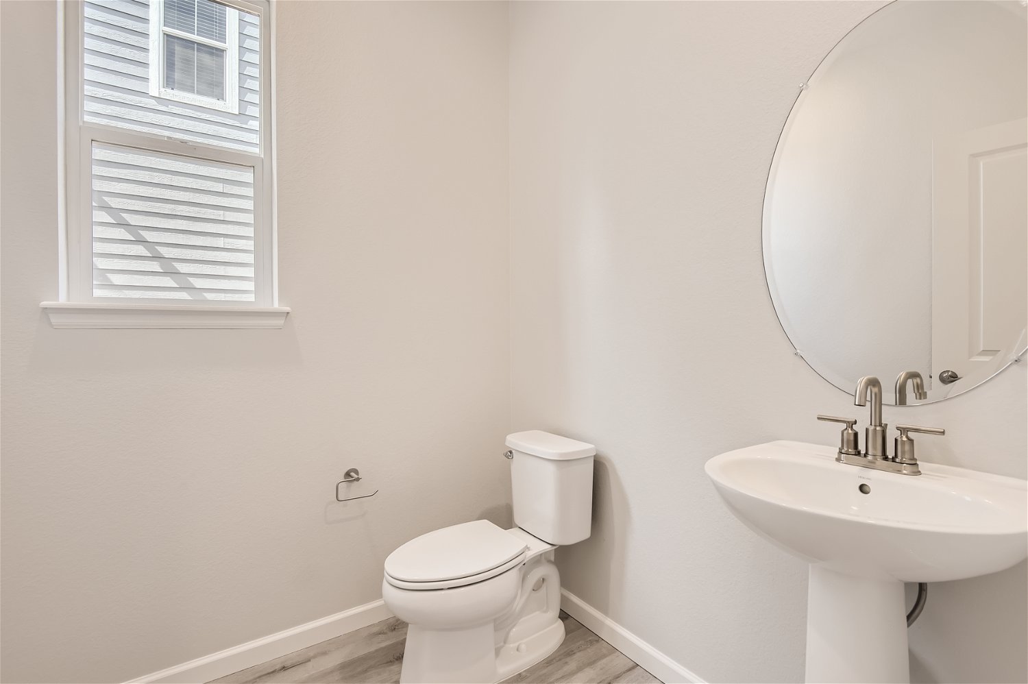 A bathroom with a round mirror.