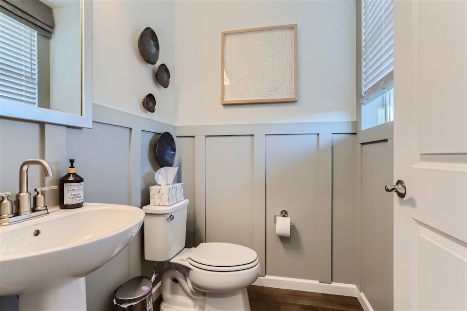 A bathroom with a toilet sink and a mirror.