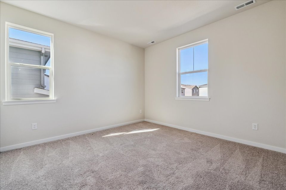 A room with a carpet and windows.