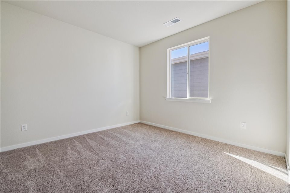 A room with a window and carpet.