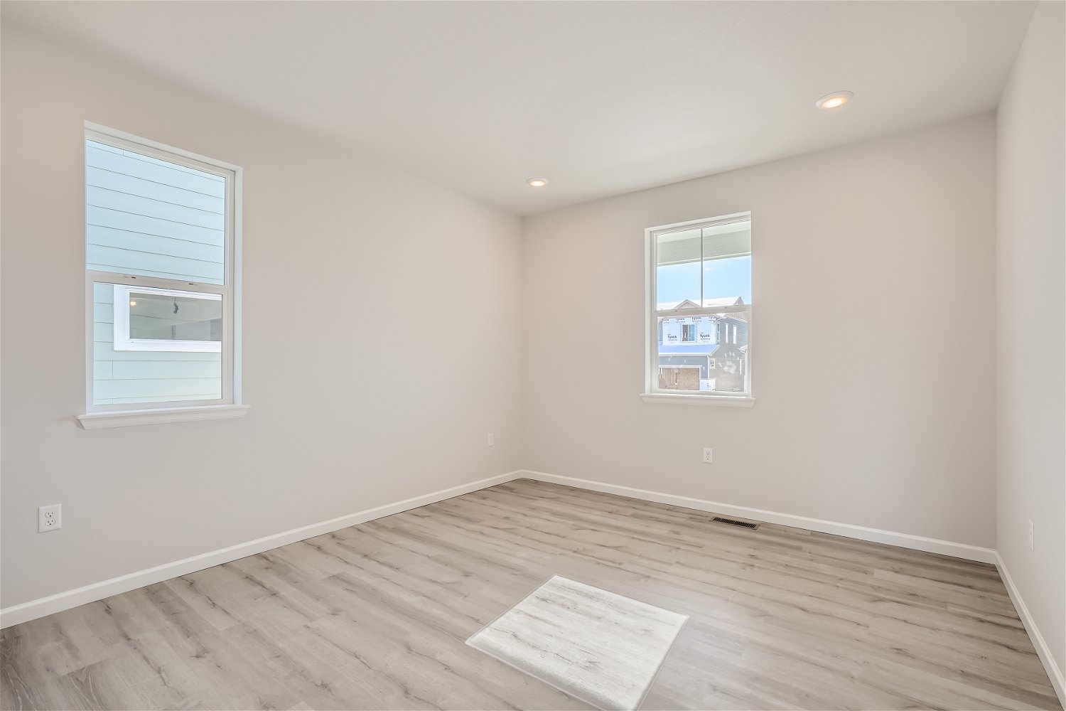 A room with windows and a paper on the floor.
