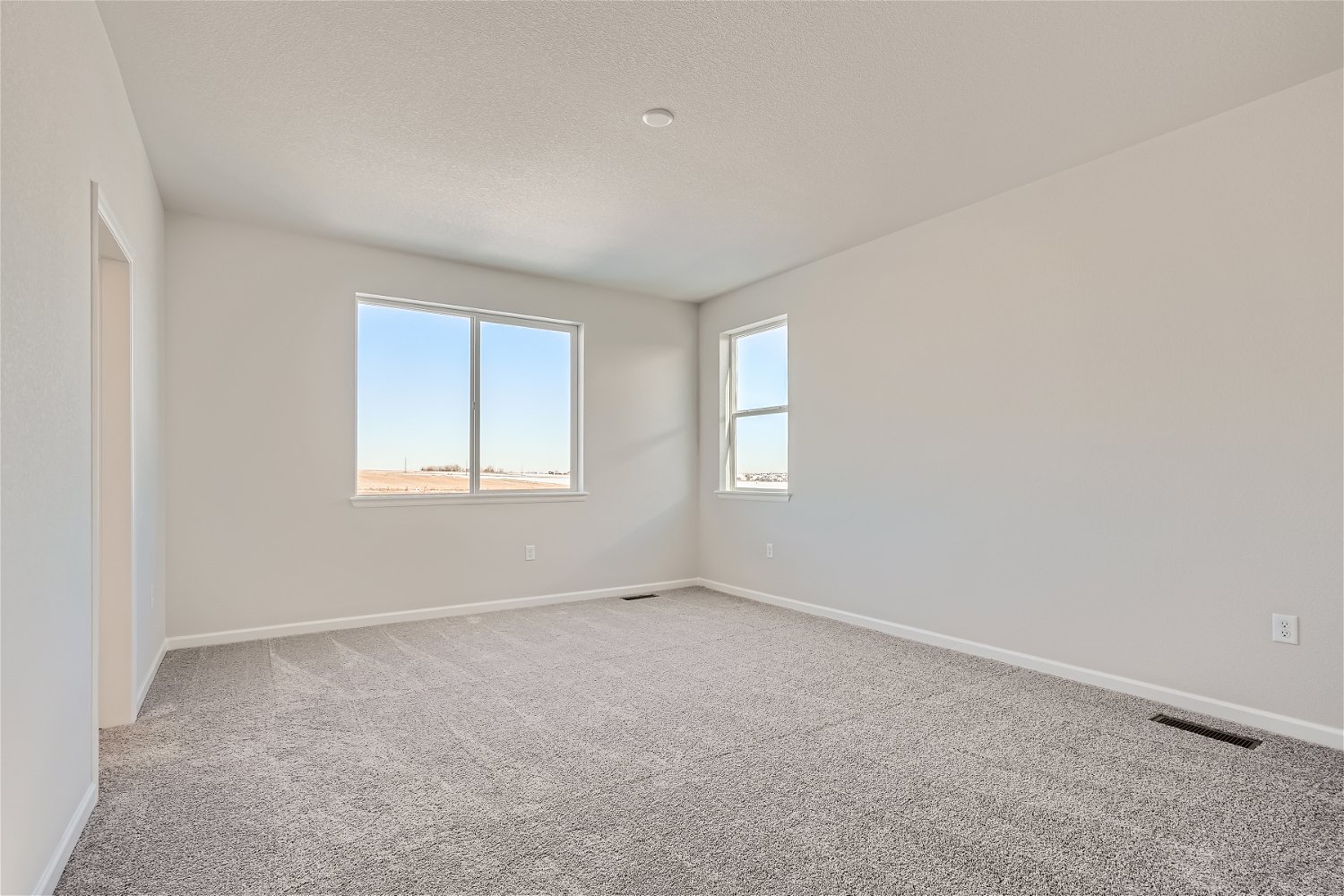 A room with a window and a carpet.