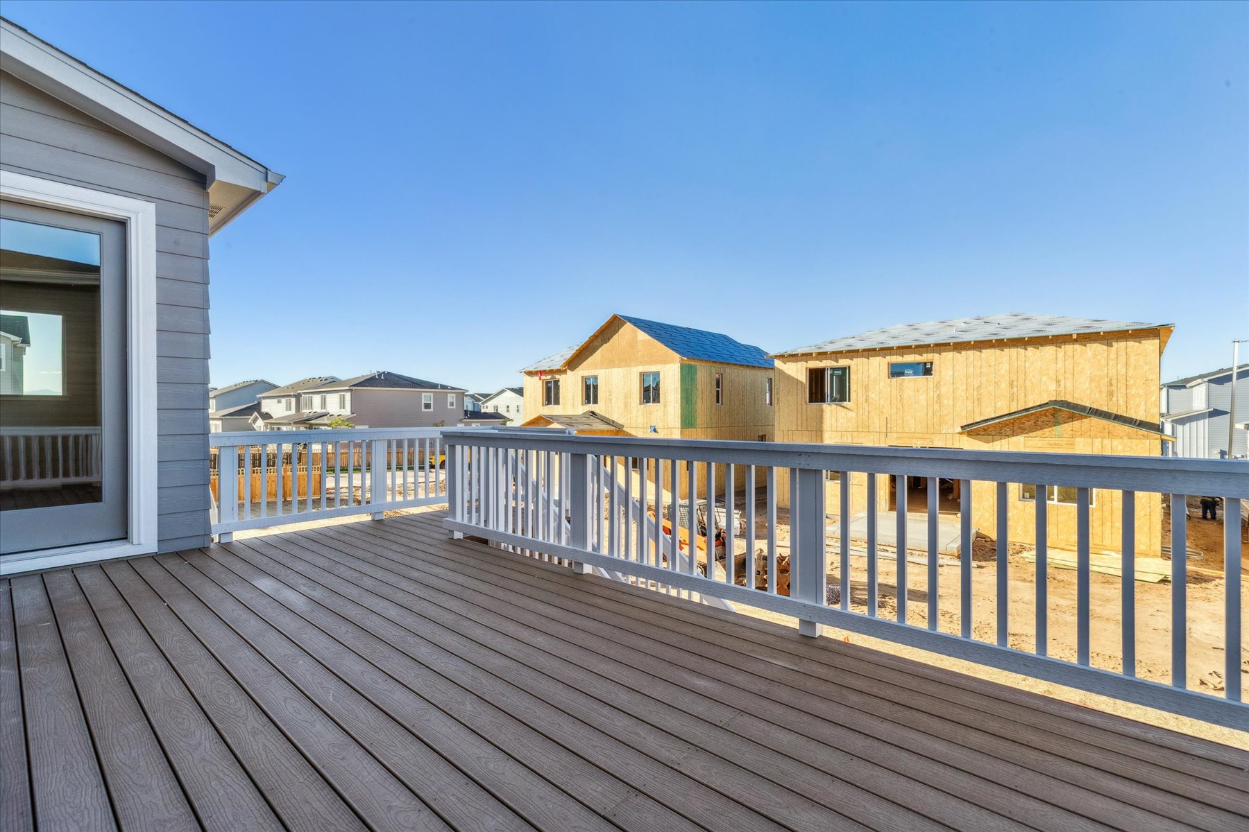 A deck with a railing and buildings in the background.