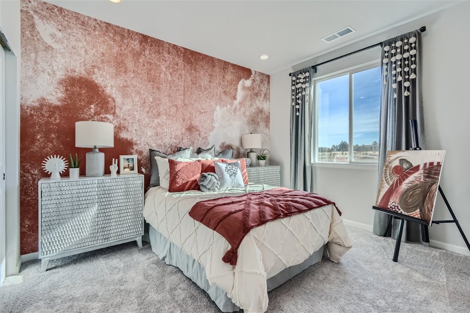 A bedroom with a bed and a chair.