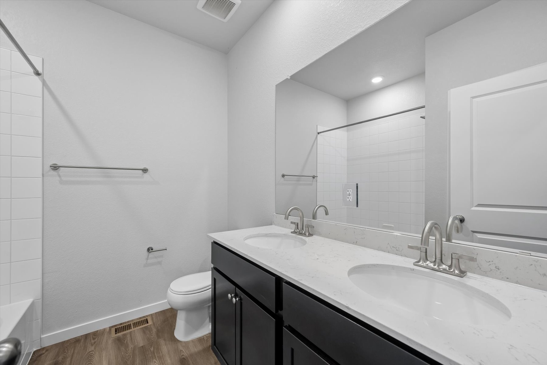 A bathroom with a sink toilet and mirror.