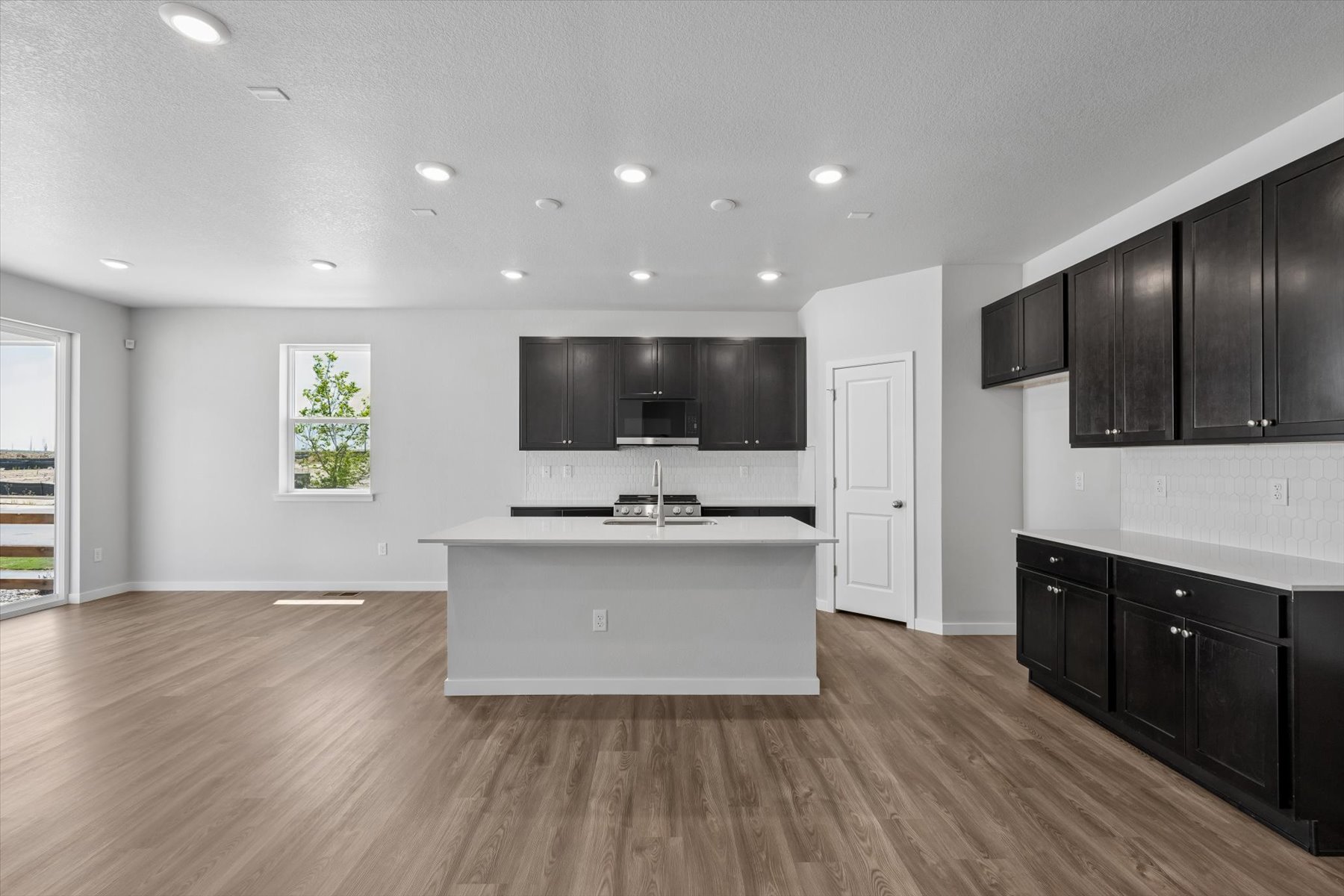 A large kitchen with black cabinets.