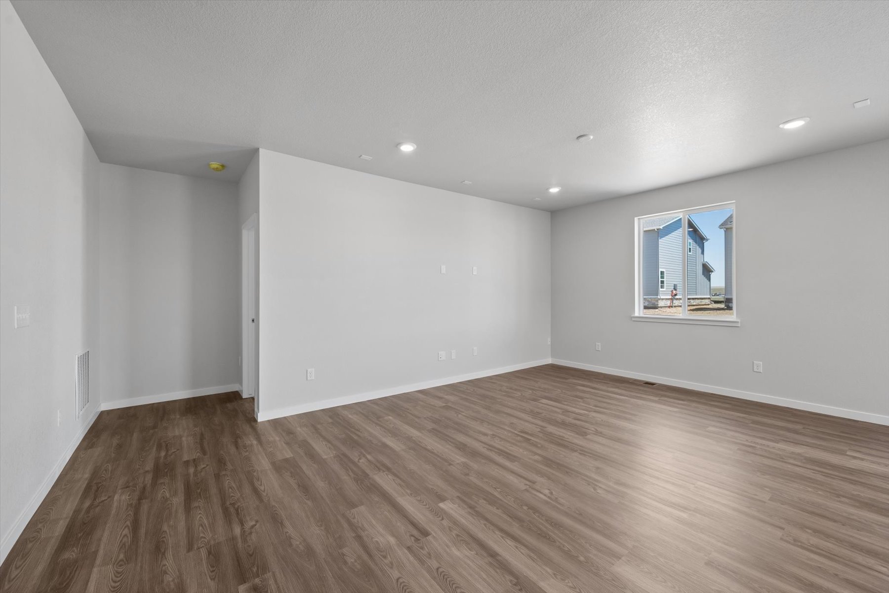 A room with a wood floor and a window.