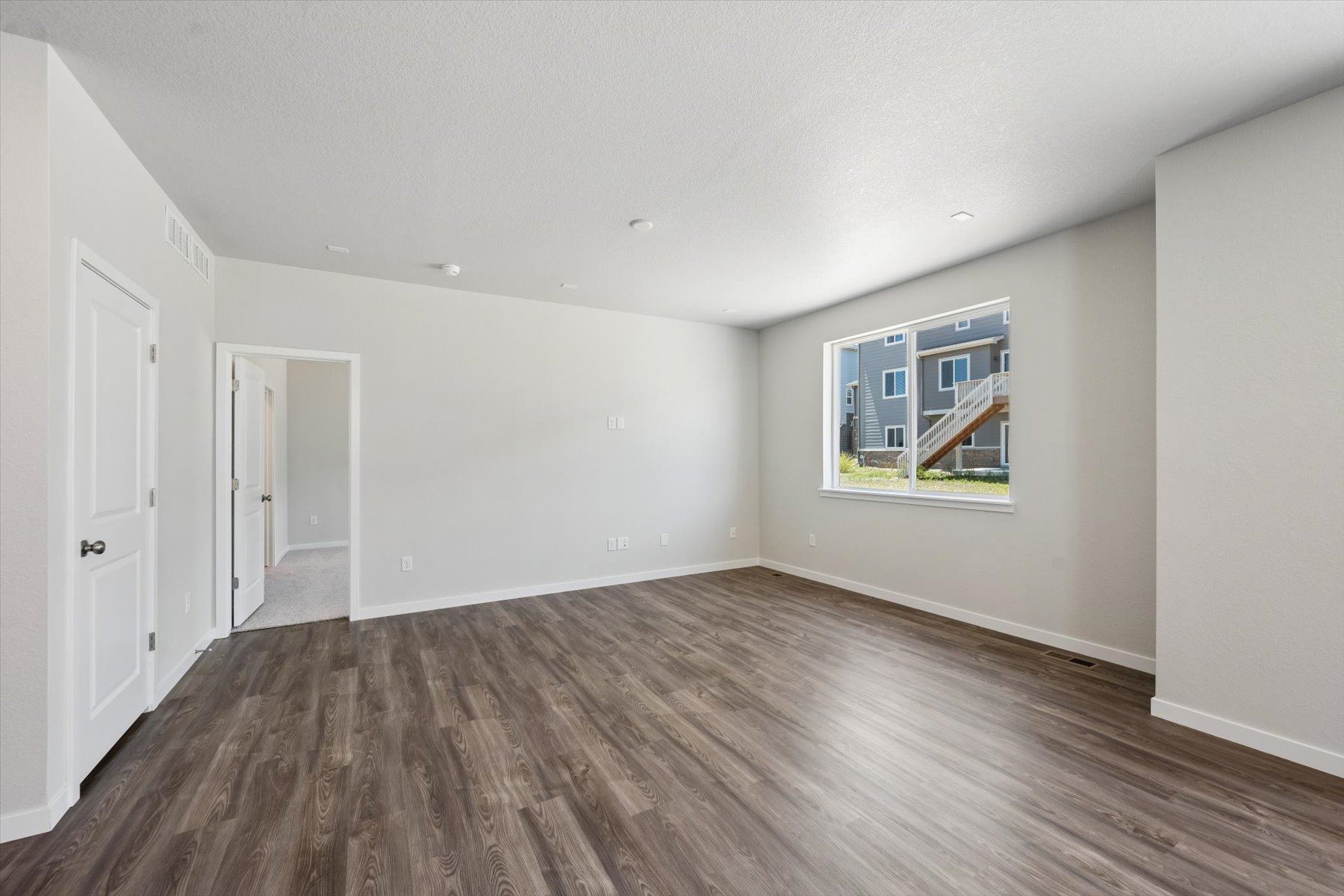 A room with a wood floor and a window.