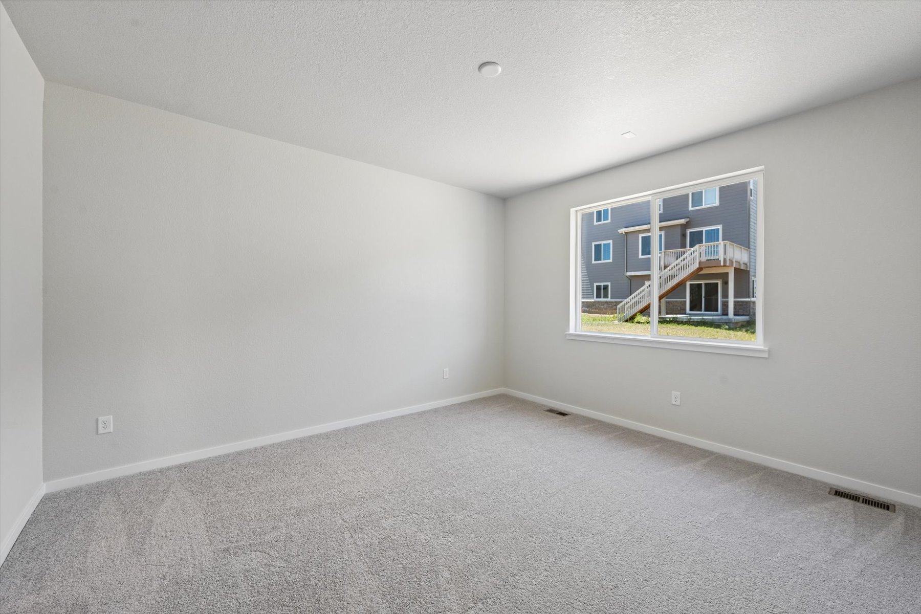 A room with a window and a white wall.