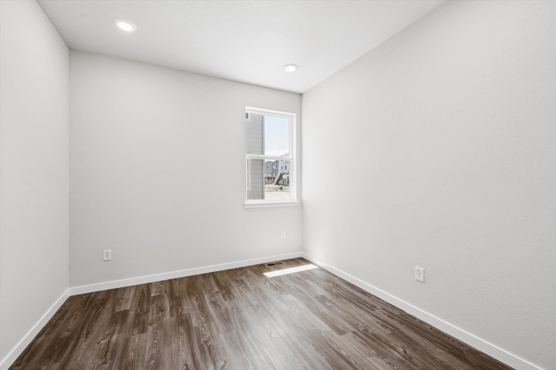 A room with a wood floor and a window.