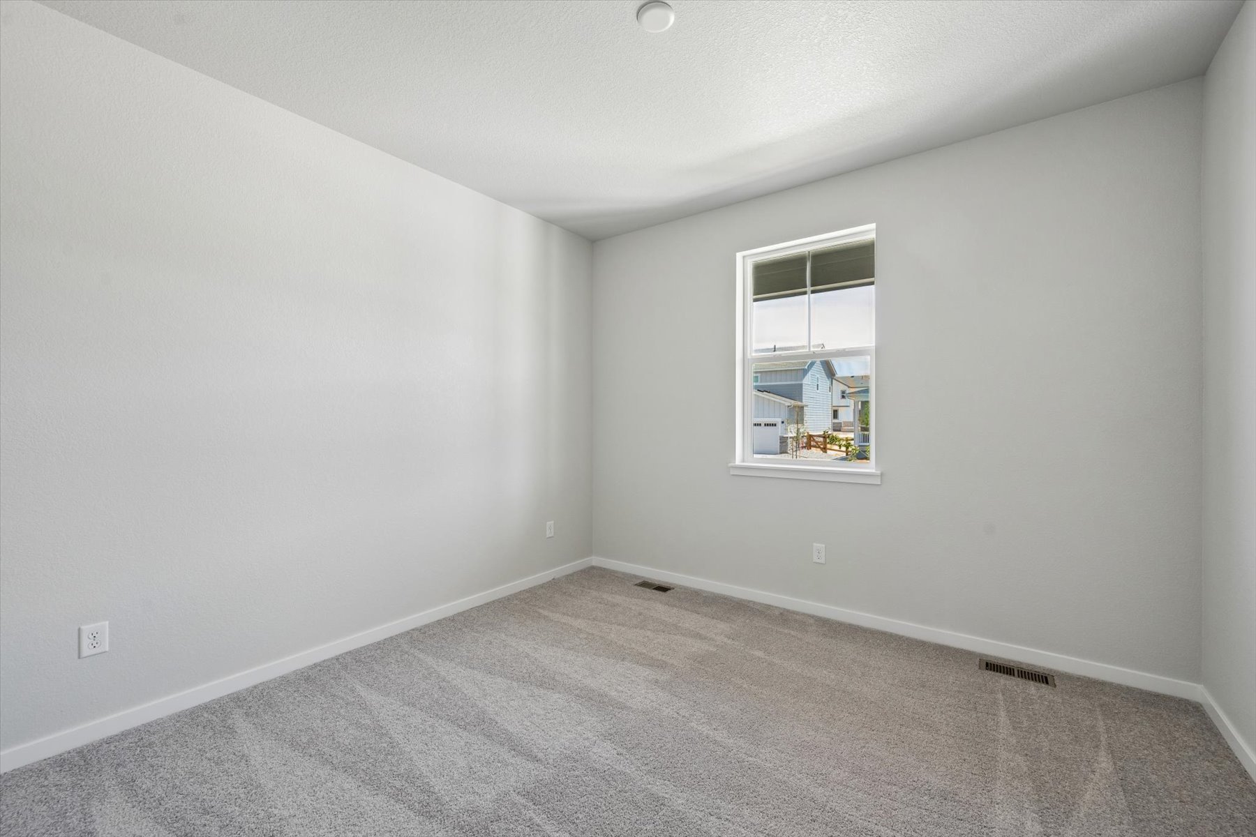 A room with a window and a rug.