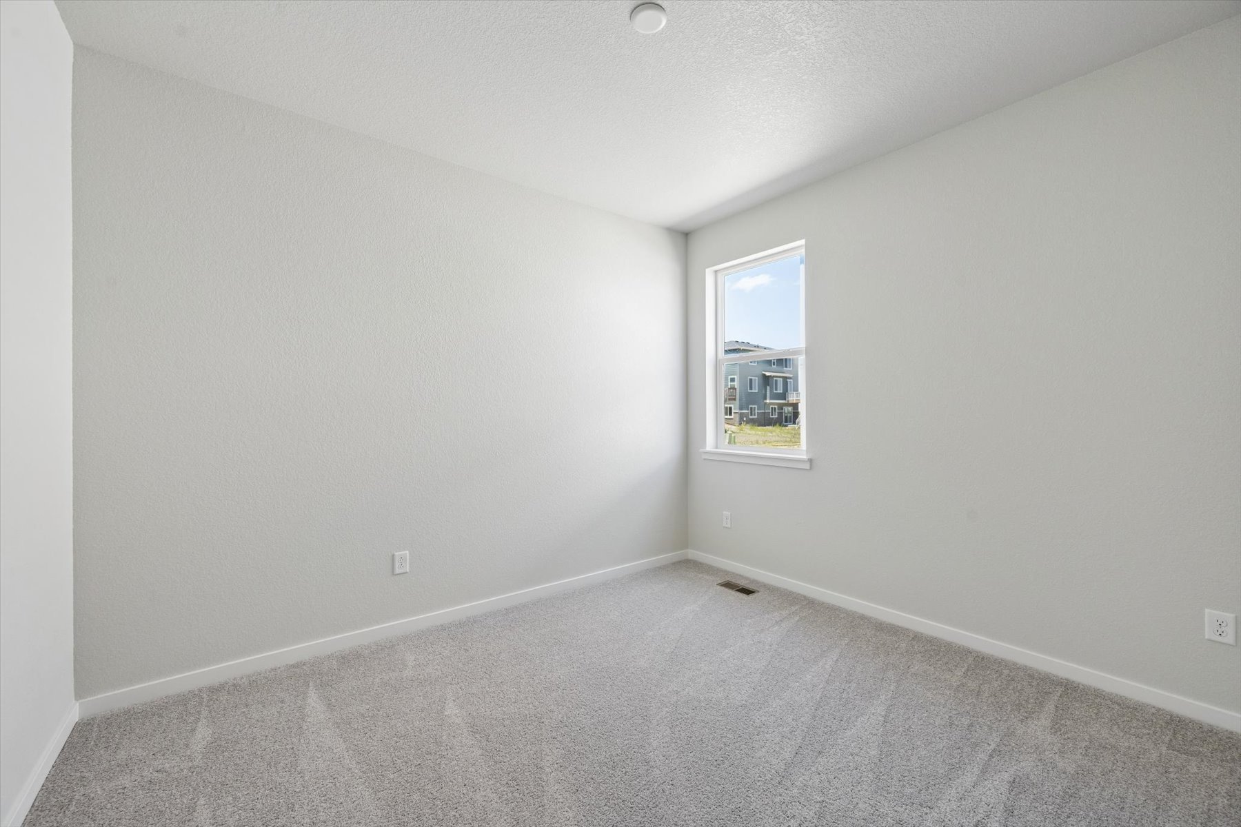 A room with a window and carpet.