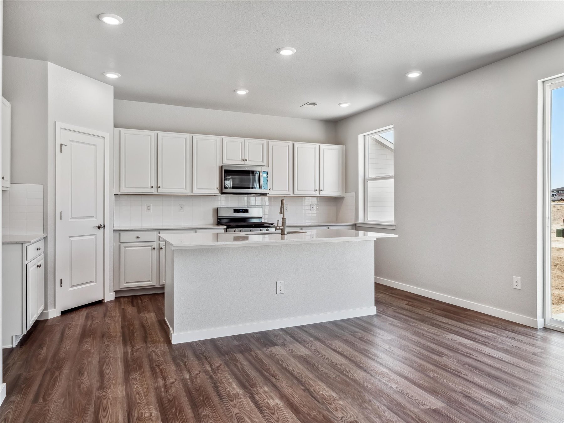 A kitchen with white cabinets.