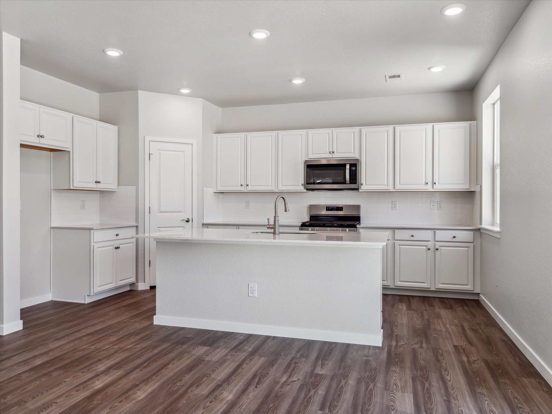 A kitchen with white cabinets.
