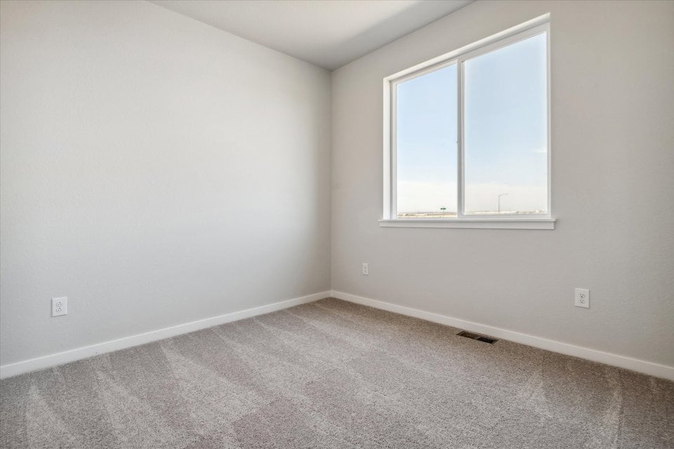 A room with a window and a carpet.