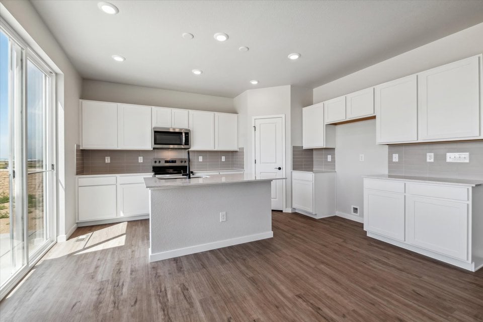 A kitchen with white cabinets.