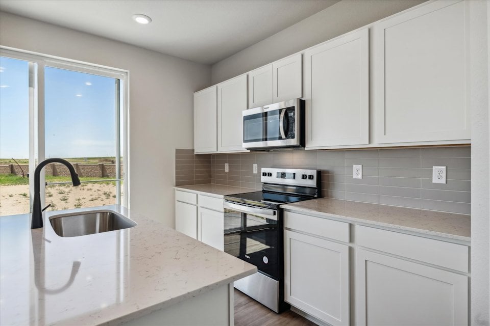 A kitchen with white cabinets.