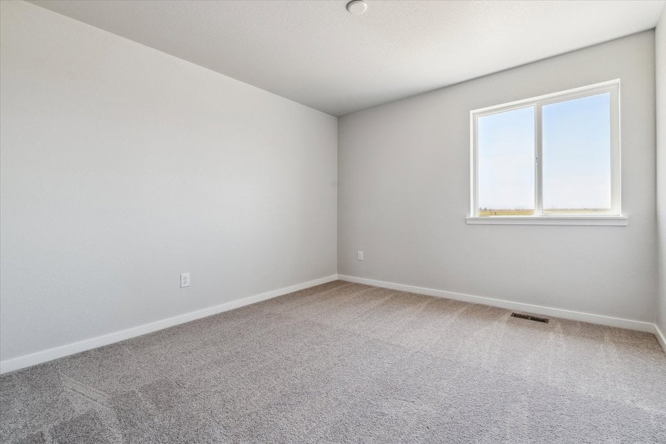 A room with a window and a carpet.