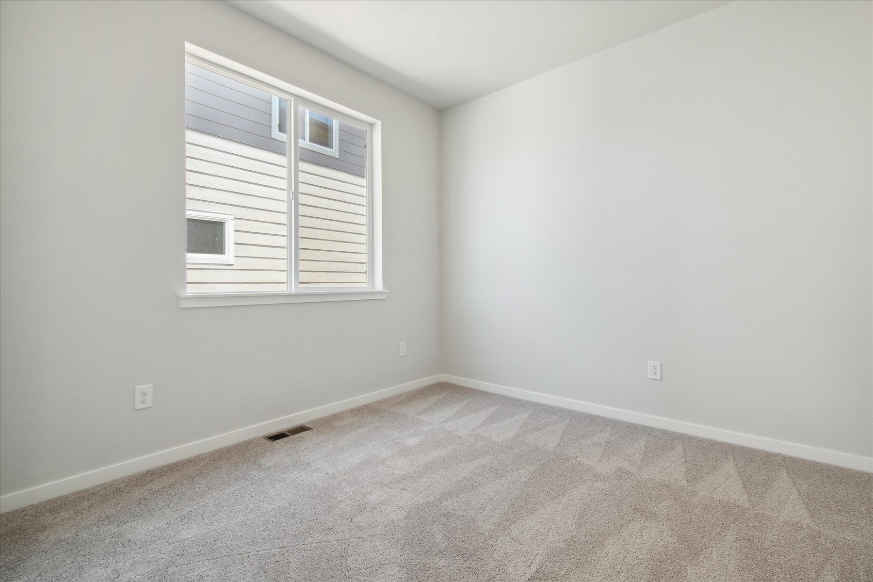 A room with a window and a carpet.