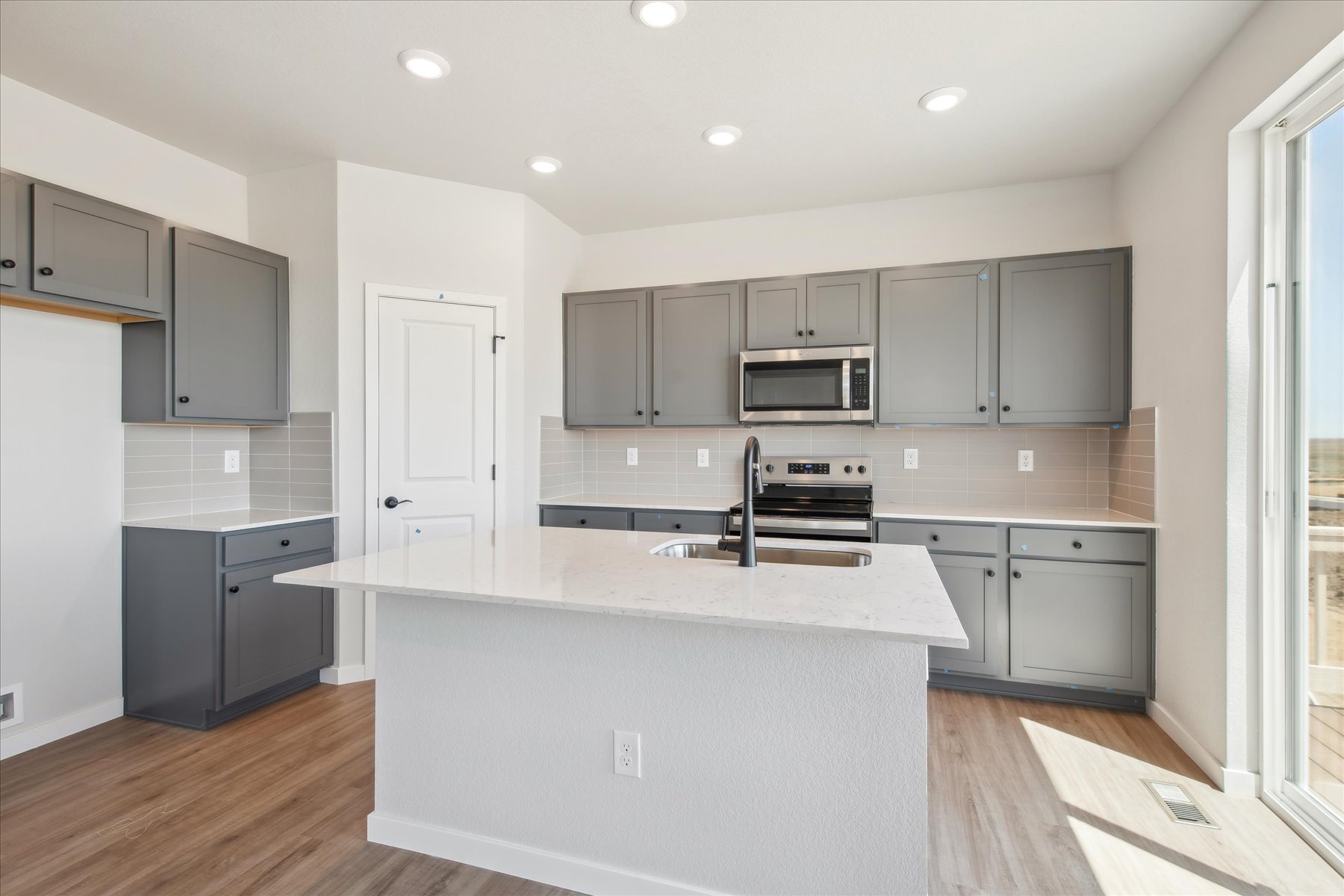 A kitchen with white cabinets.
