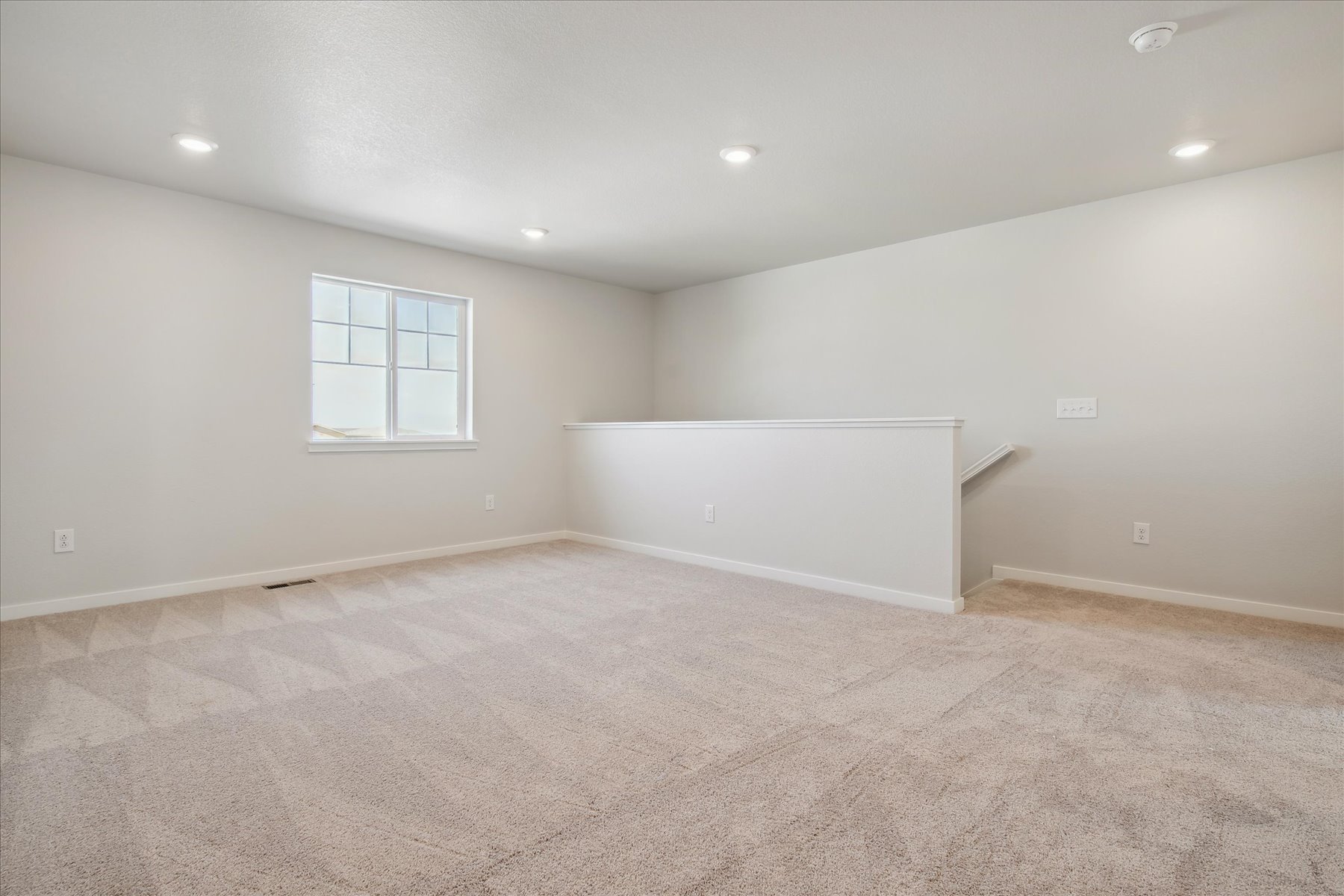 A room with a carpet and a window.