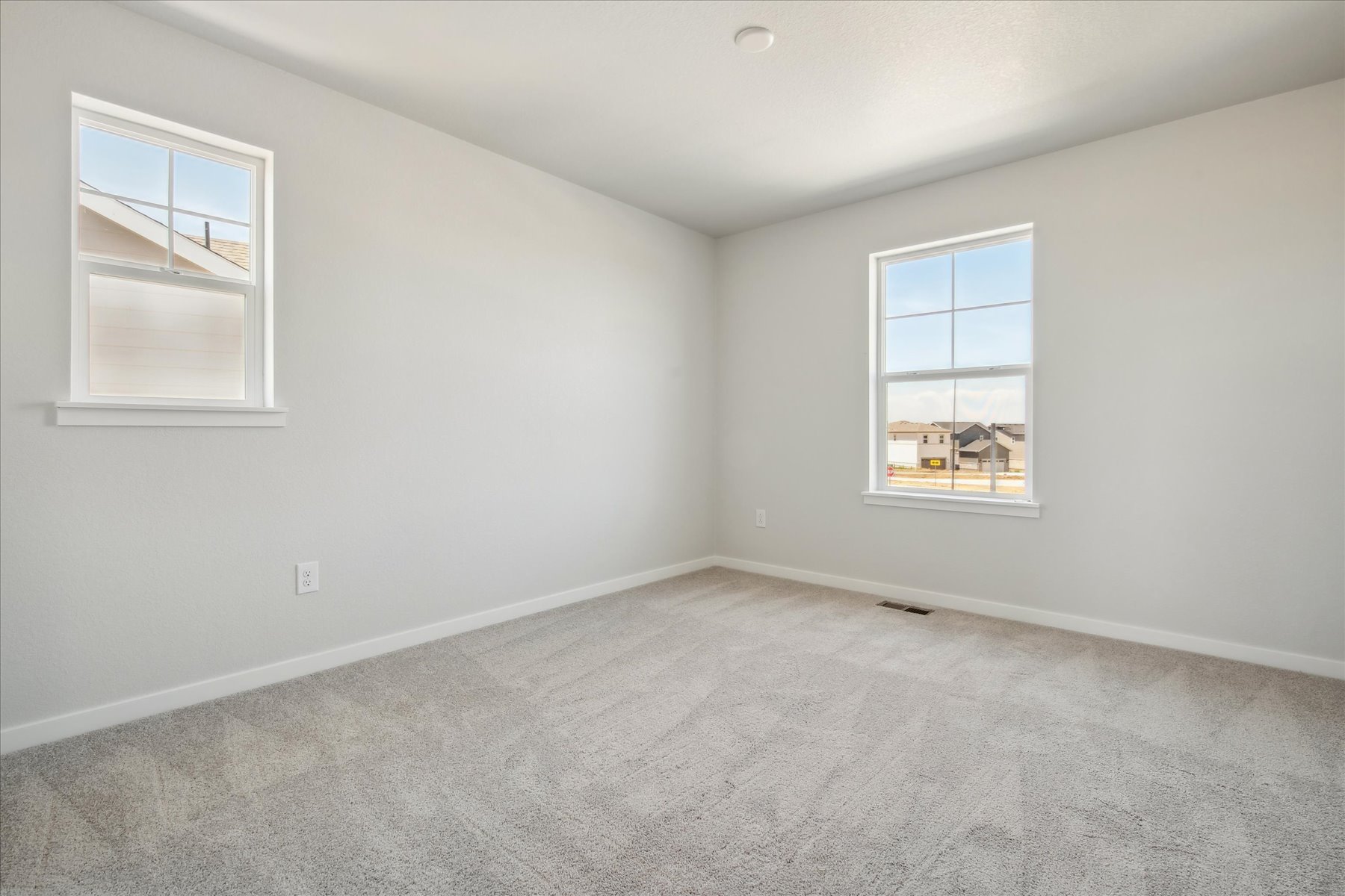 A room with windows and a carpet.
