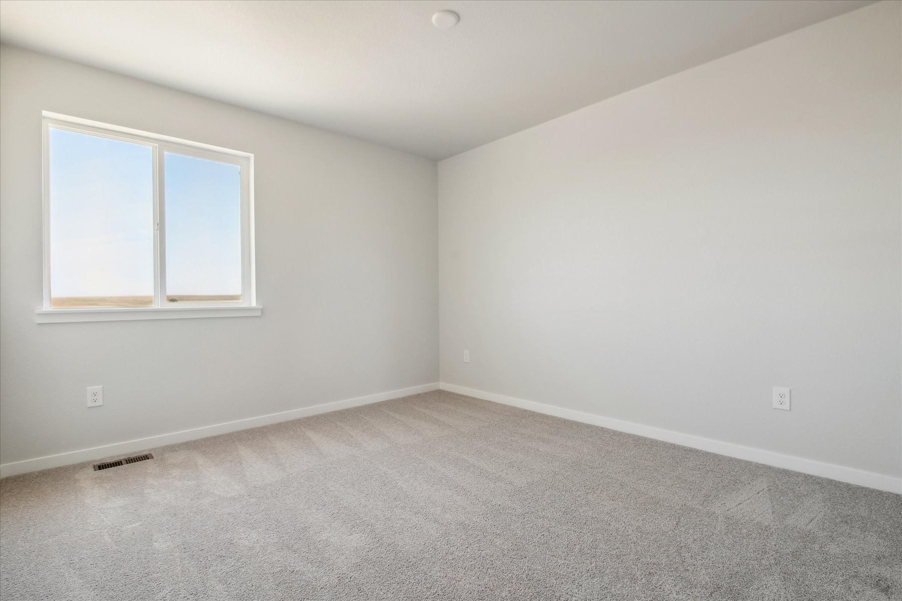 A room with a window and a carpet.