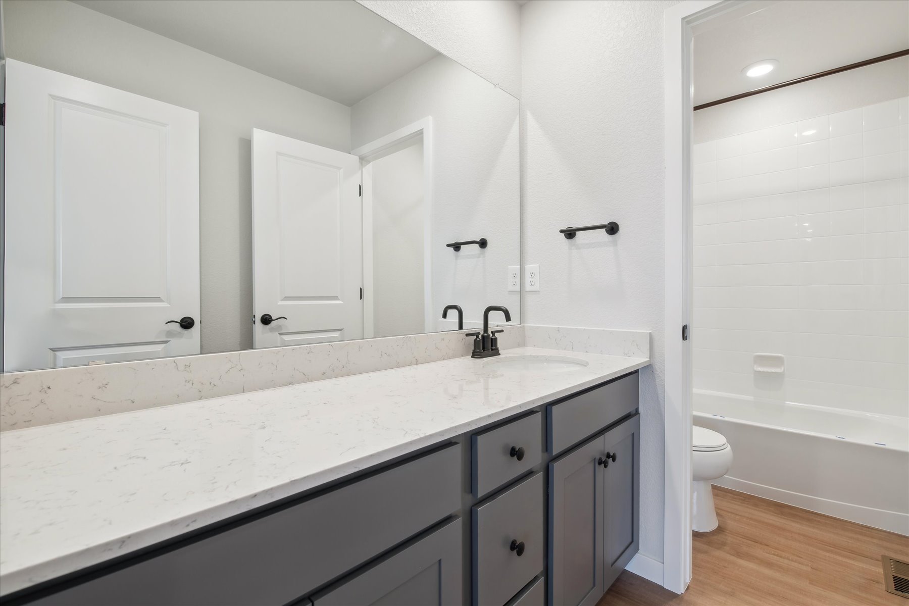 A bathroom with a tub sink and toilet.
