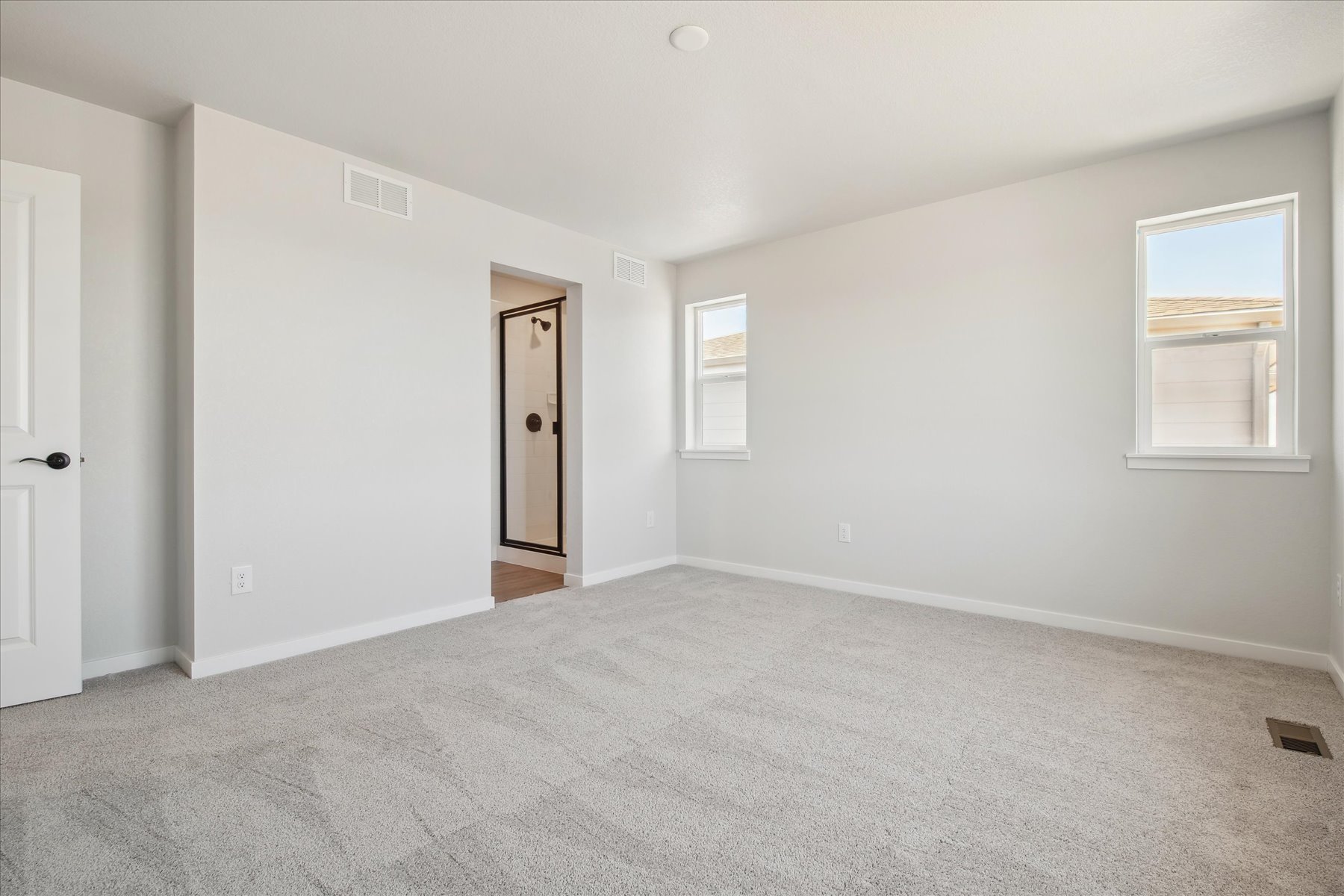 A room with a carpet and a door.