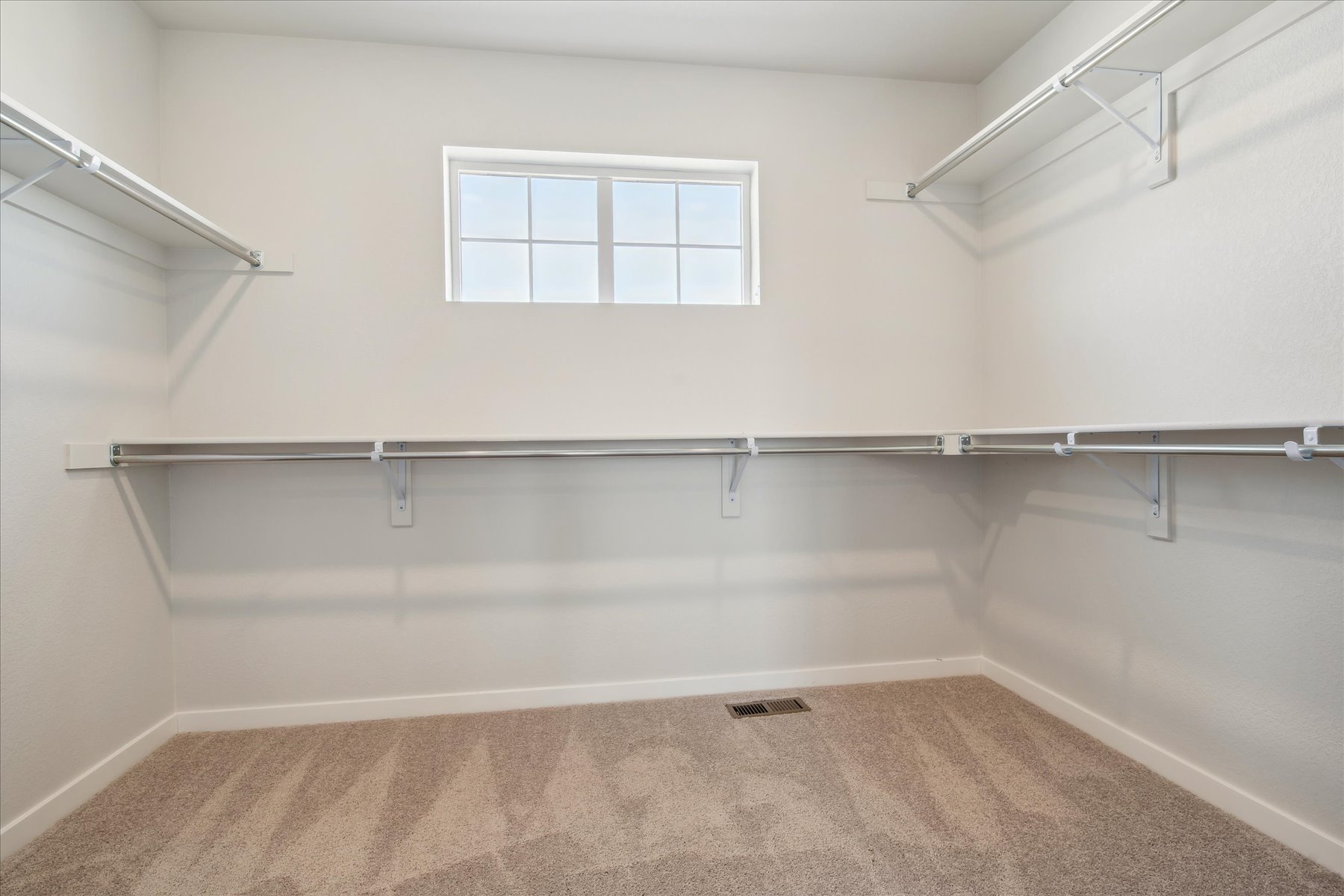 A room with a window and a metal railing.