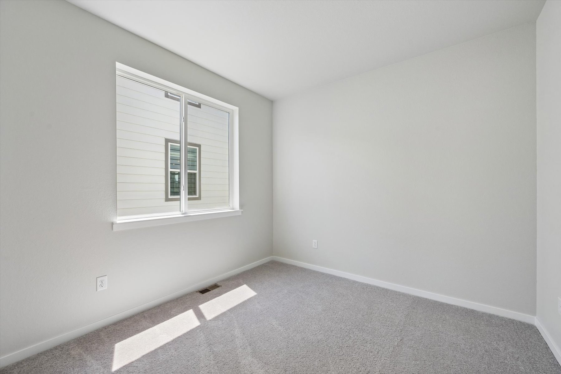 A room with a window and a carpet.
