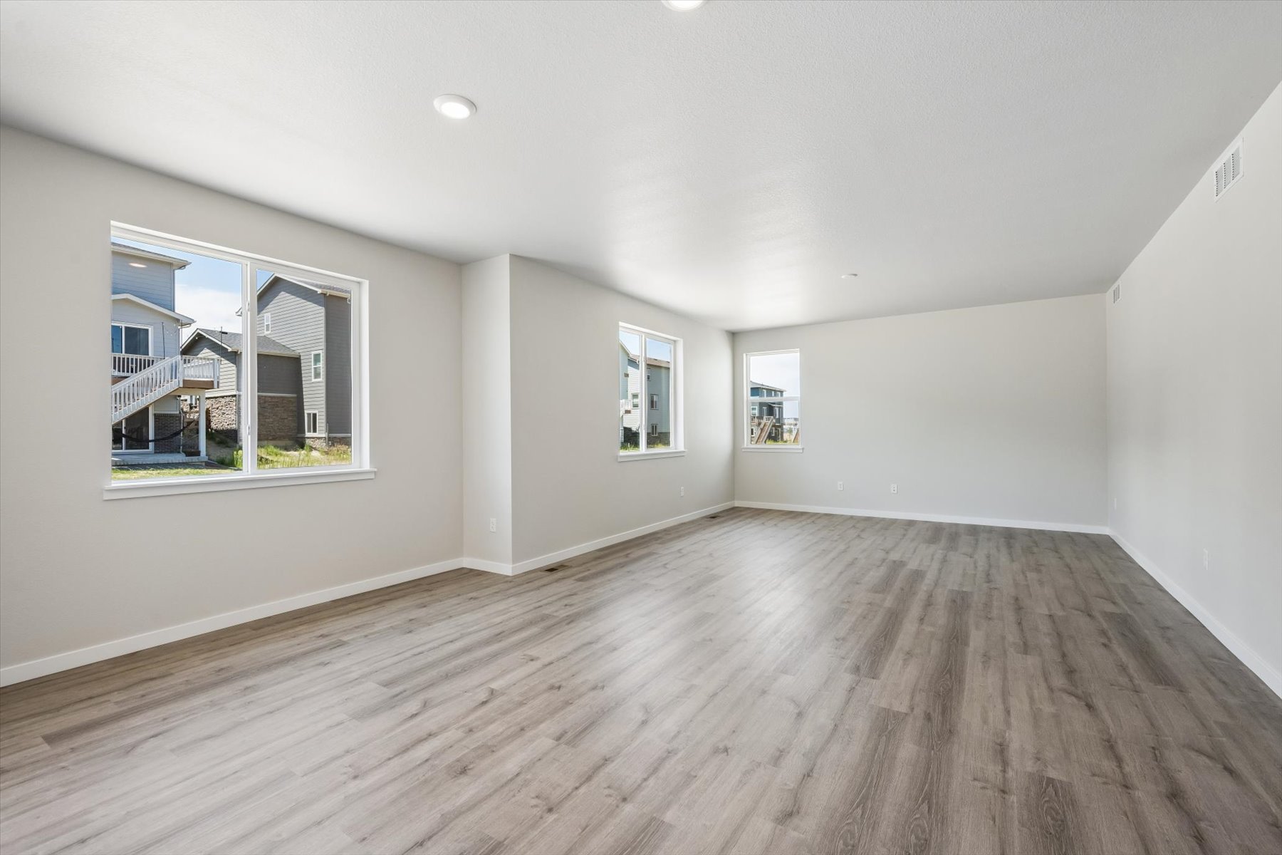 A room with a wood floor and a window with a wood floor.