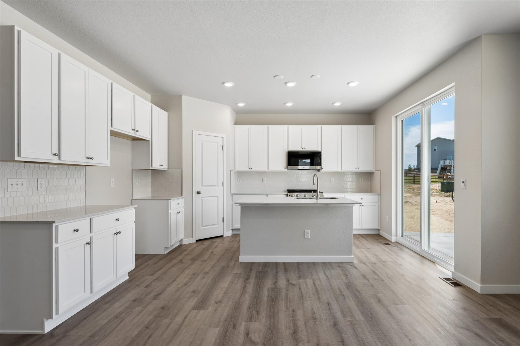 A kitchen with white cabinets.