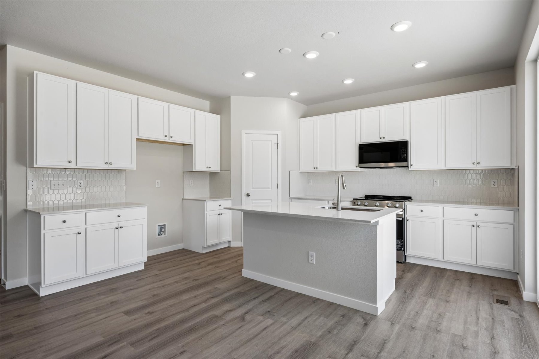 A kitchen with white cabinets.