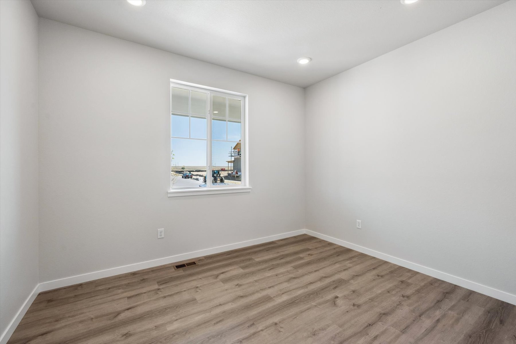 A room with a wood floor and a window.