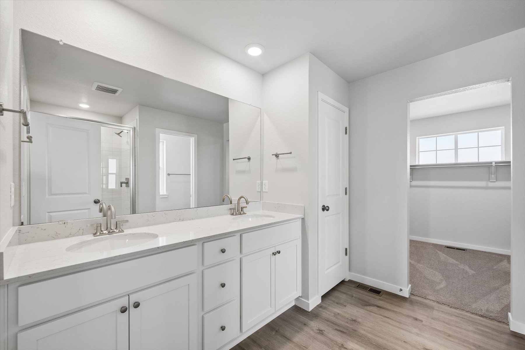 A bathroom with white cabinets.