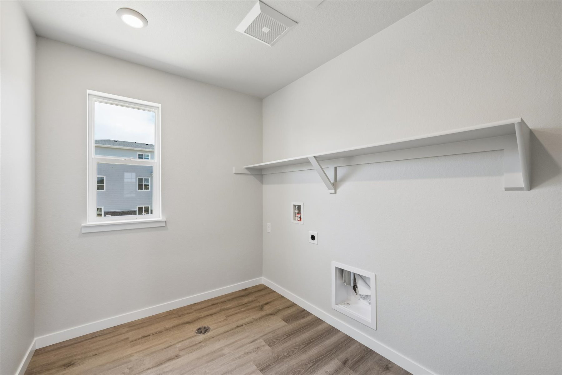 A room with a wood floor and a window.