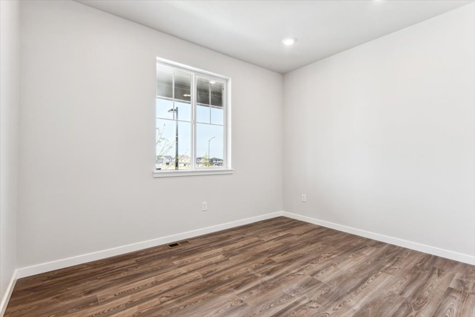 A room with a wood floor and a window.