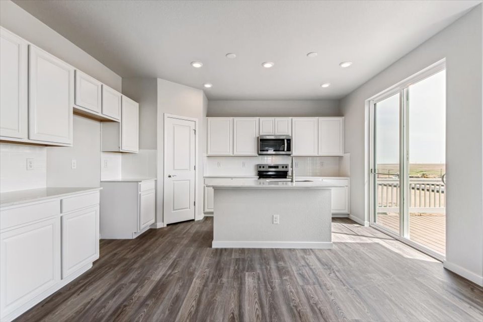 A kitchen with white cabinets.