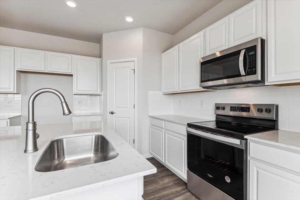 A kitchen with white cabinets.