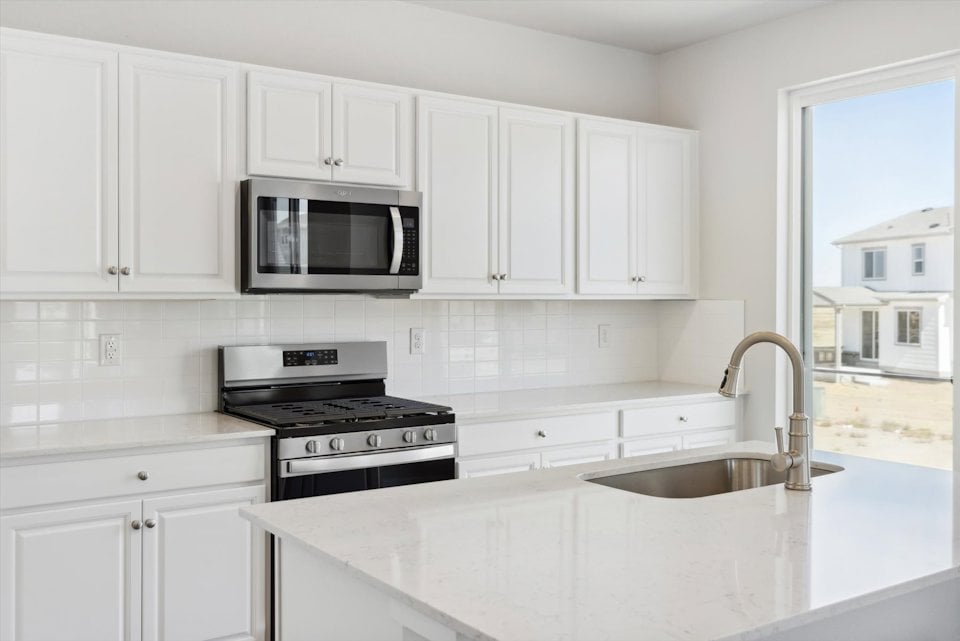 A kitchen with white cabinets.