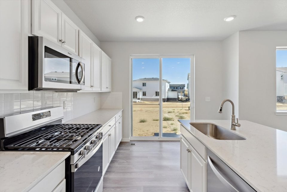 A kitchen with white cabinets.